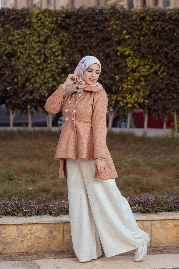 Model wearing Camel Coat, perfect for a timeless and elegant look. عارضة ترتدي معطف باللون الجملي، مثالي لإطلالة كلاسيكية وأنيقة.