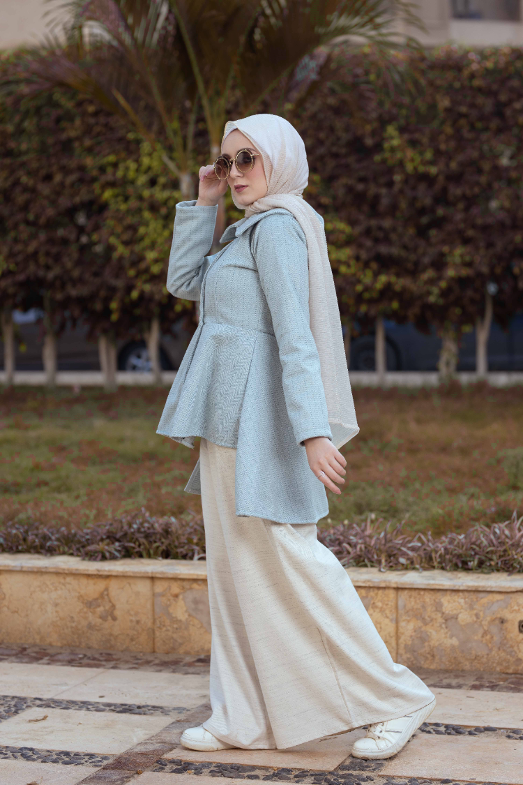 Side view of Mint Coat showcasing the long sleeves and tailored fit. معطف باللون الأخضر النعناعي يظهر الأكمام الطويلة والتصميم المصمم بعناية، منظر جانبي.