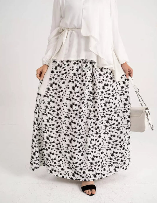 Front view of White Flowy Skirt with an airy fabric and relaxed fit. تنورة بيضاء انسيابية بقماش خفيف وتصميم مريح، منظر أمامي.