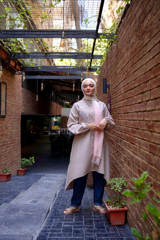 Front view of Long Shirt in Beige featuring a button-down design and long sleeves. قميص طويل باللون البيج بتصميم بأزرار أمامية وأكمام طويلة، منظر أمامي.