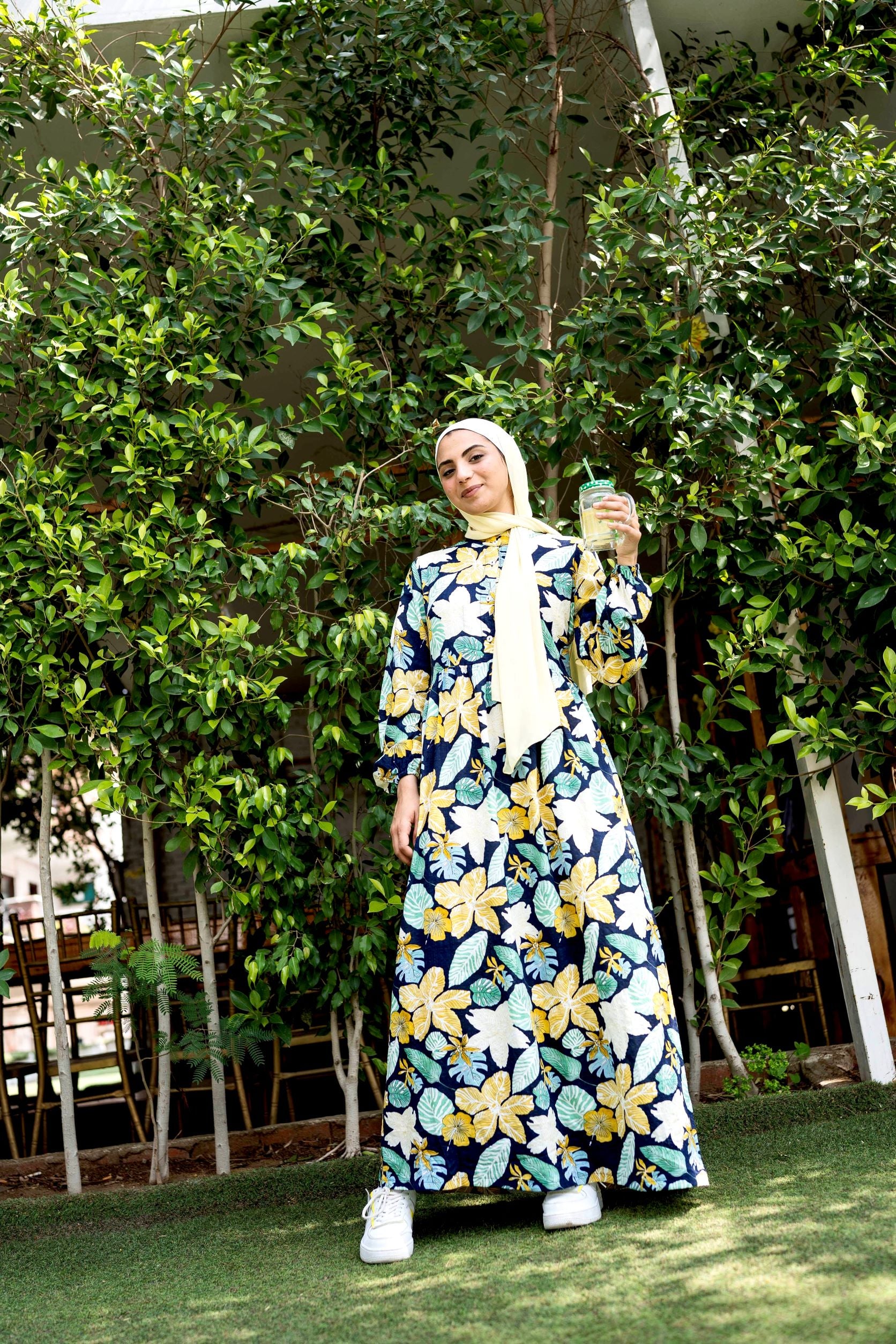 Front view of Tropical Dress featuring a vibrant floral pattern and long sleeves. فستان استوائي بنقشة زهور زاهية وأكمام طويلة، منظر أمامي.