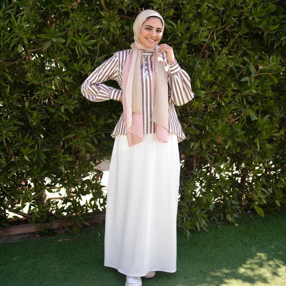 Model wearing Brown Striped Blouse, highlighting the horizontal stripes and long sleeves. عارضة ترتدي بلوزة باللون البني مخططة، مع إبراز الخطوط الأفقية والأكمام الطويلة.