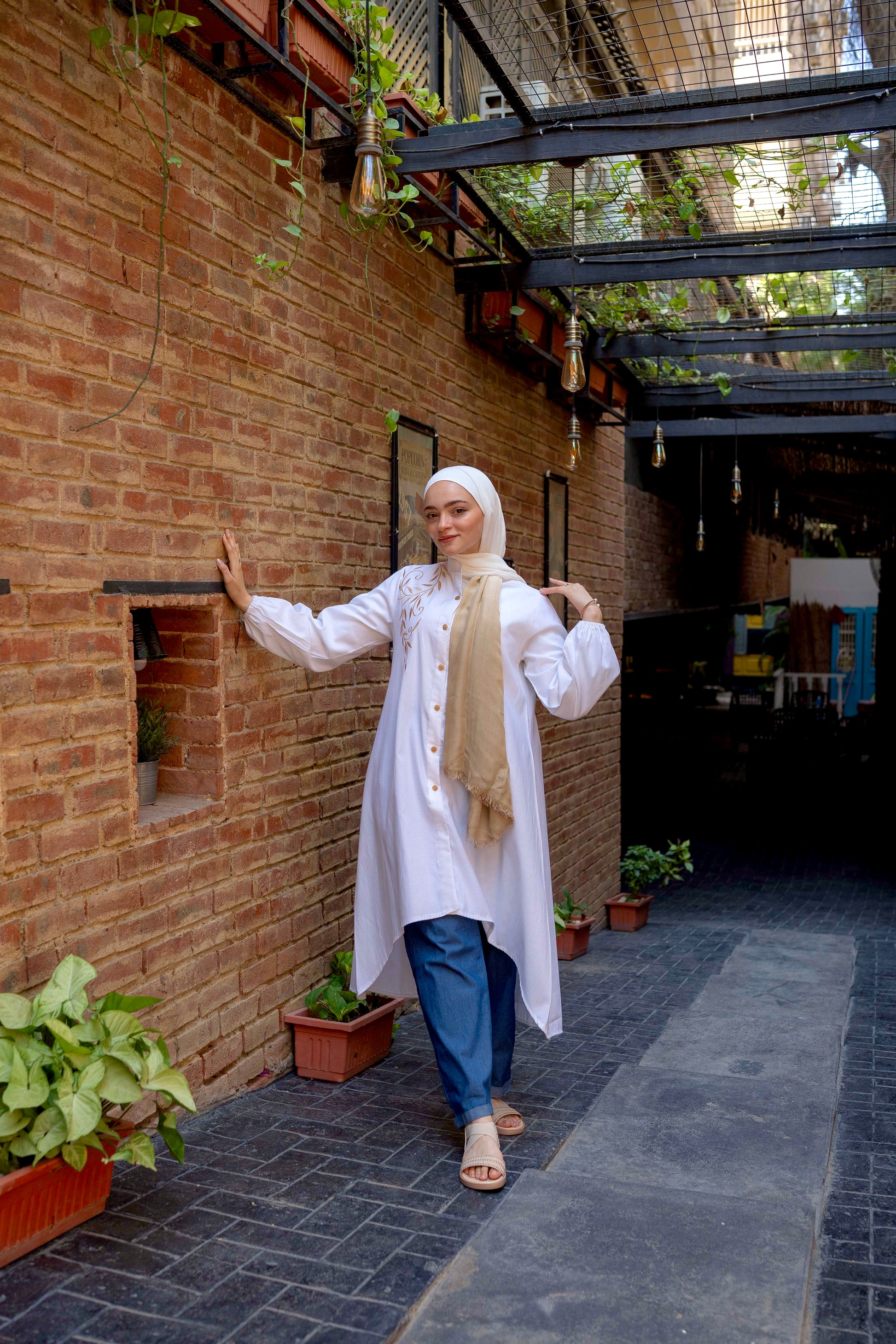 Front view of Long Shirt in White with a relaxed fit and button-down design. قميص طويل باللون الأبيض بتصميم مريح وأزرار أمامية، منظر أمامي.