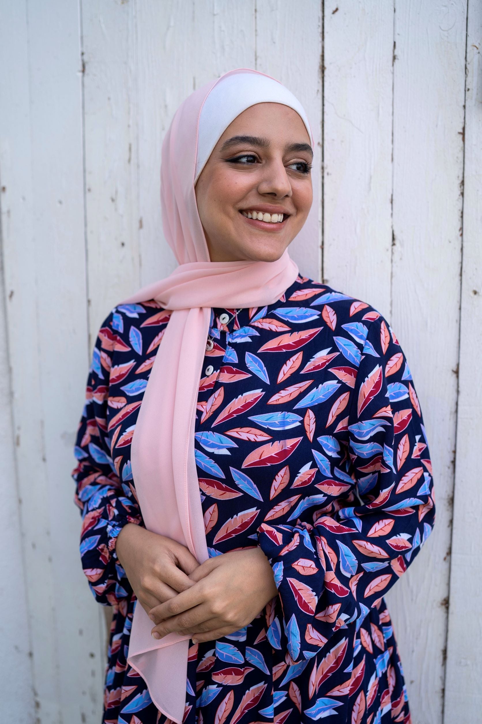 Model wearing Leaves Dress, showcasing the leaf pattern and long sleeves. عارضة ترتدي فستان بأوراق الشجر بنمط أوراق وأكمام طويلة.