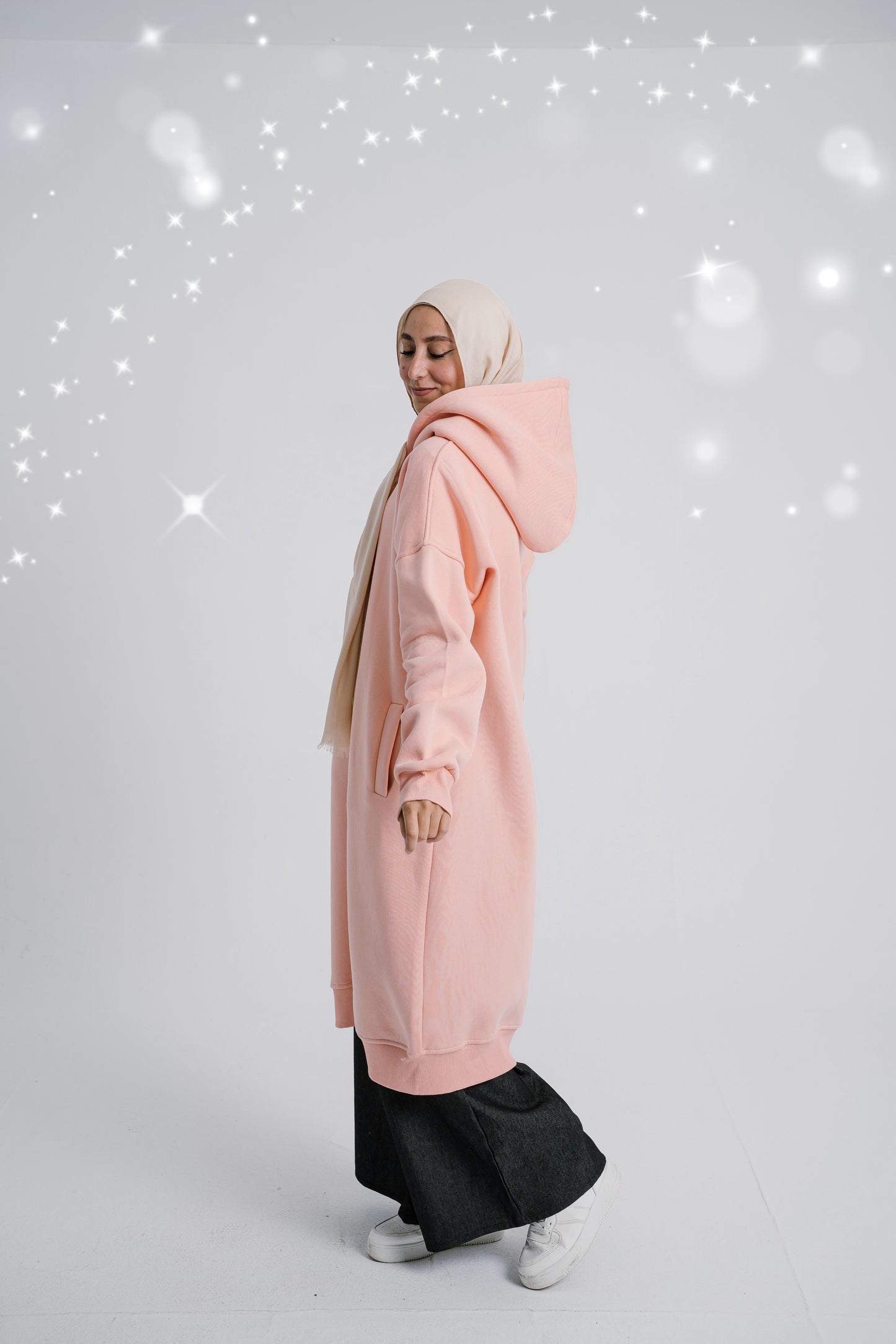 Side view of Simon Frost Hoodie showcasing the hood and relaxed fit. سويت شيرت باللون السيمون يظهر غطاء الرأس والتصميم المريح، منظر جانبي.