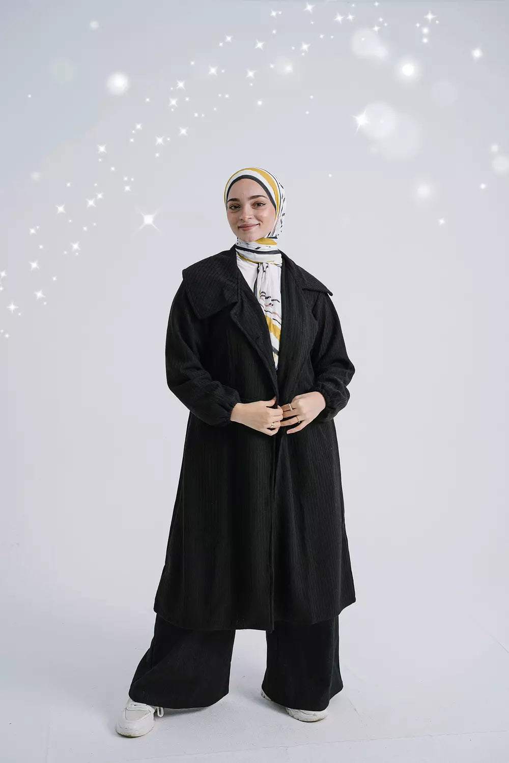 Front view of Enchanted Black Cardigan featuring an open-front design and long sleeves. سترة باللون الأسود الداكن بتصميم مفتوح من الأمام وأكمام طويلة، منظر أمامي.