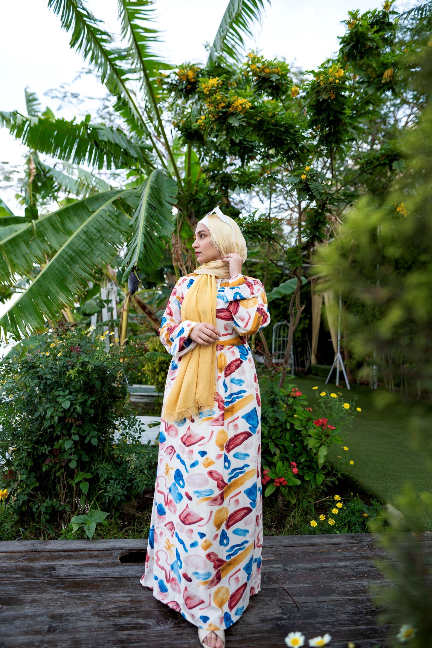 Front view of Sea Stones Dress in White with sea-inspired pattern and long sleeves. فستان بأحجار البحر باللون الأبيض مع نمط مستوحى من البحر وأكمام طويلة، منظر أمامي.