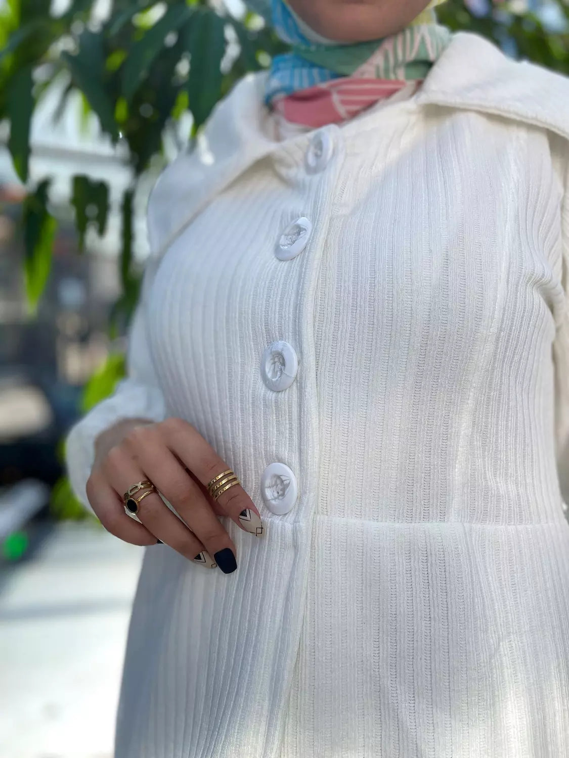 Close-up of the fabric texture of Enchanted White Cardigan. صورة مقربة لنسيج سترة باللون الأبيض.