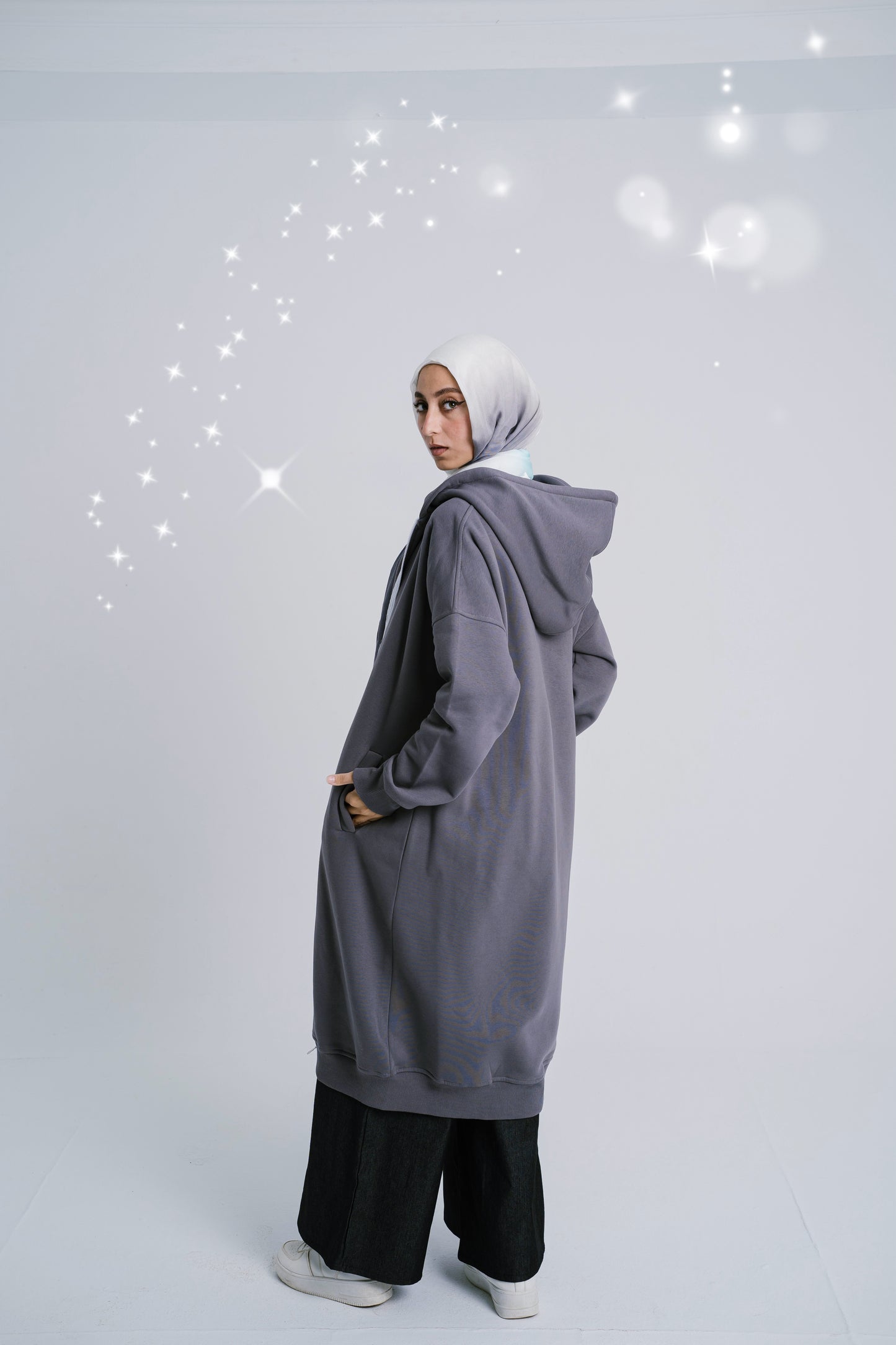 Back view of Gray Frost Hoodie featuring the cool gray color and hood. سويت شيرت باللون الرمادي البارد مع غطاء رأس، منظر خلفي.